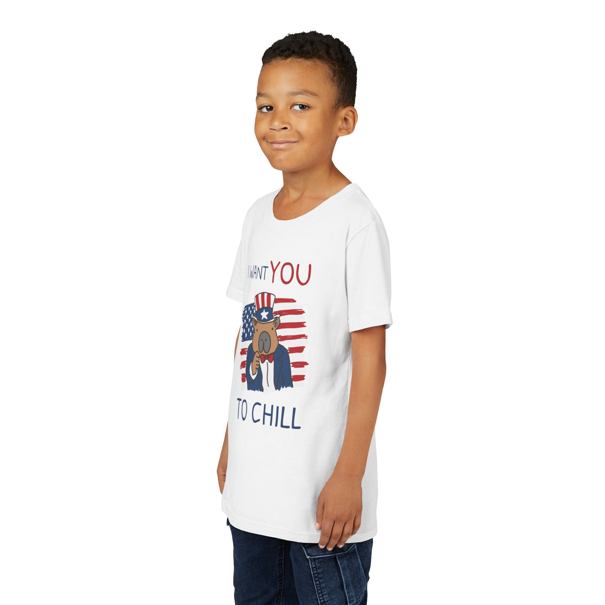 A young boy wearing a Capy Life white t-shirt featuring a patriotic capybara graphic with the text I Want You to Chill