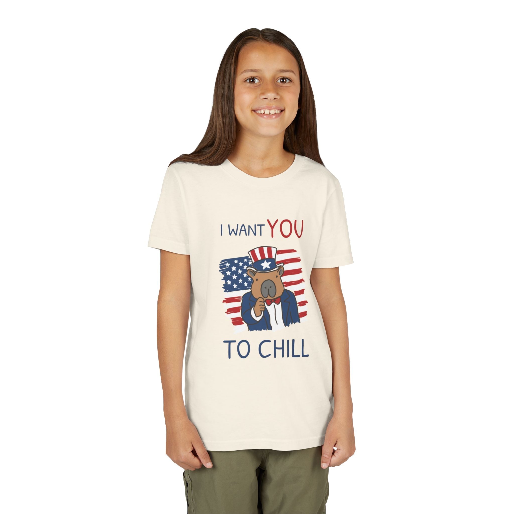 Young girl wearing a Capy Life cream t-shirt with a patriotic capybara graphic and I Want You To Chill text