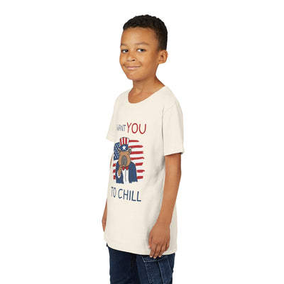 Young boy wearing a Capy Life cream t-shirt with a patriotic capybara graphic and I Want You to Chill text