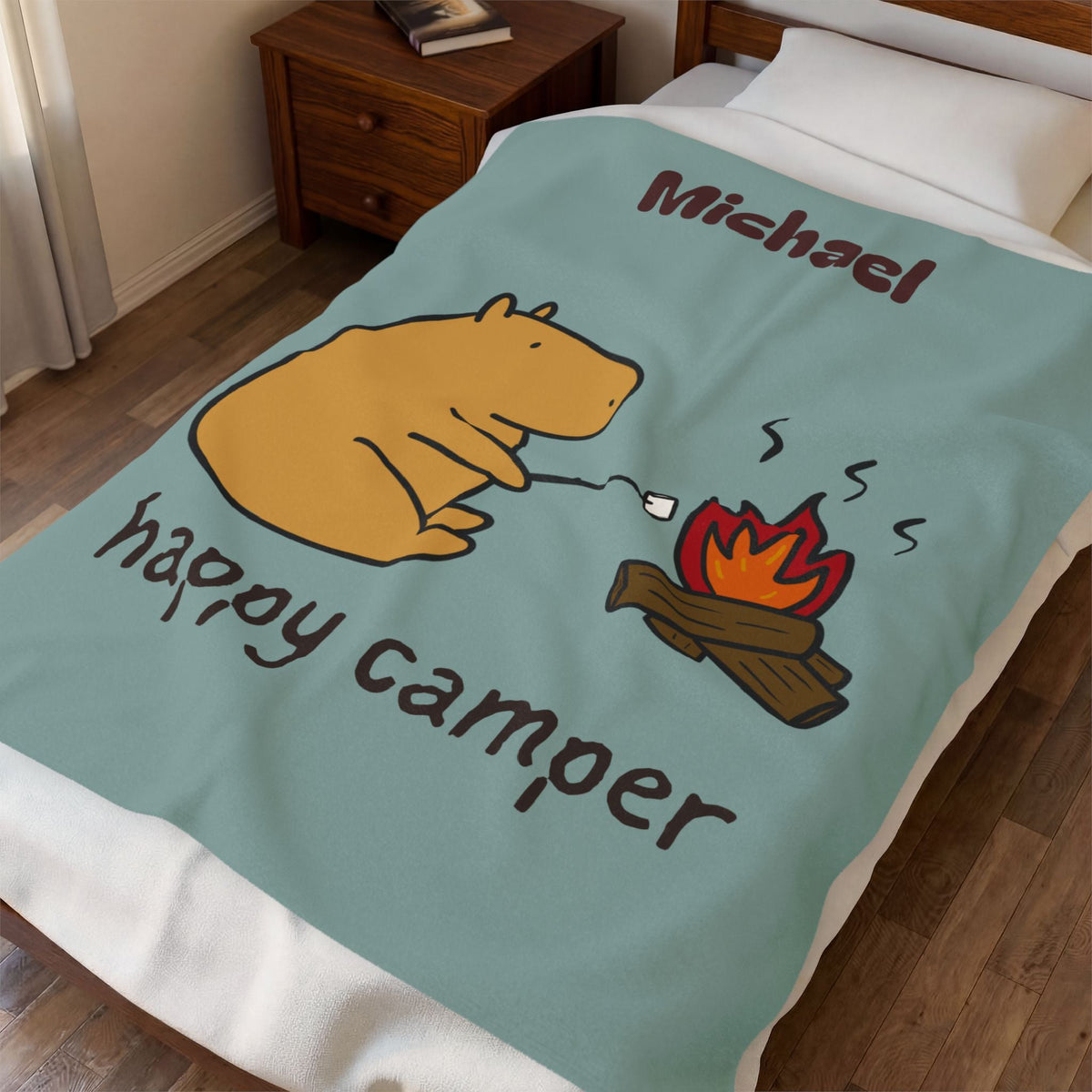 Capy Life personalized sage-green blanket featuring Gene the Capybara roasting a marshmallow by a campfire