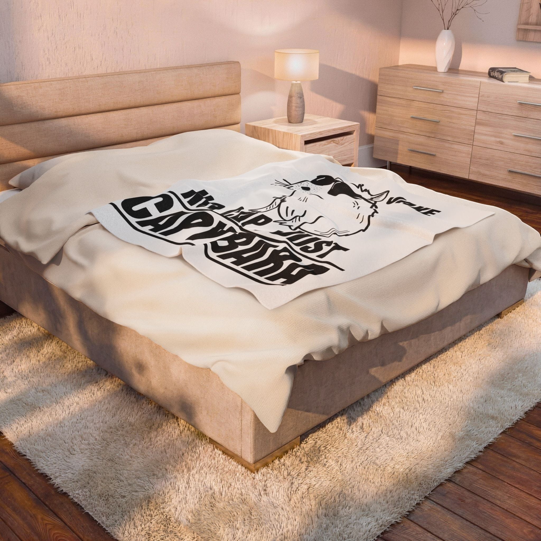 Capy Life personalized fleece blanket with capybara graphic draped over a cozy bedroom bed.