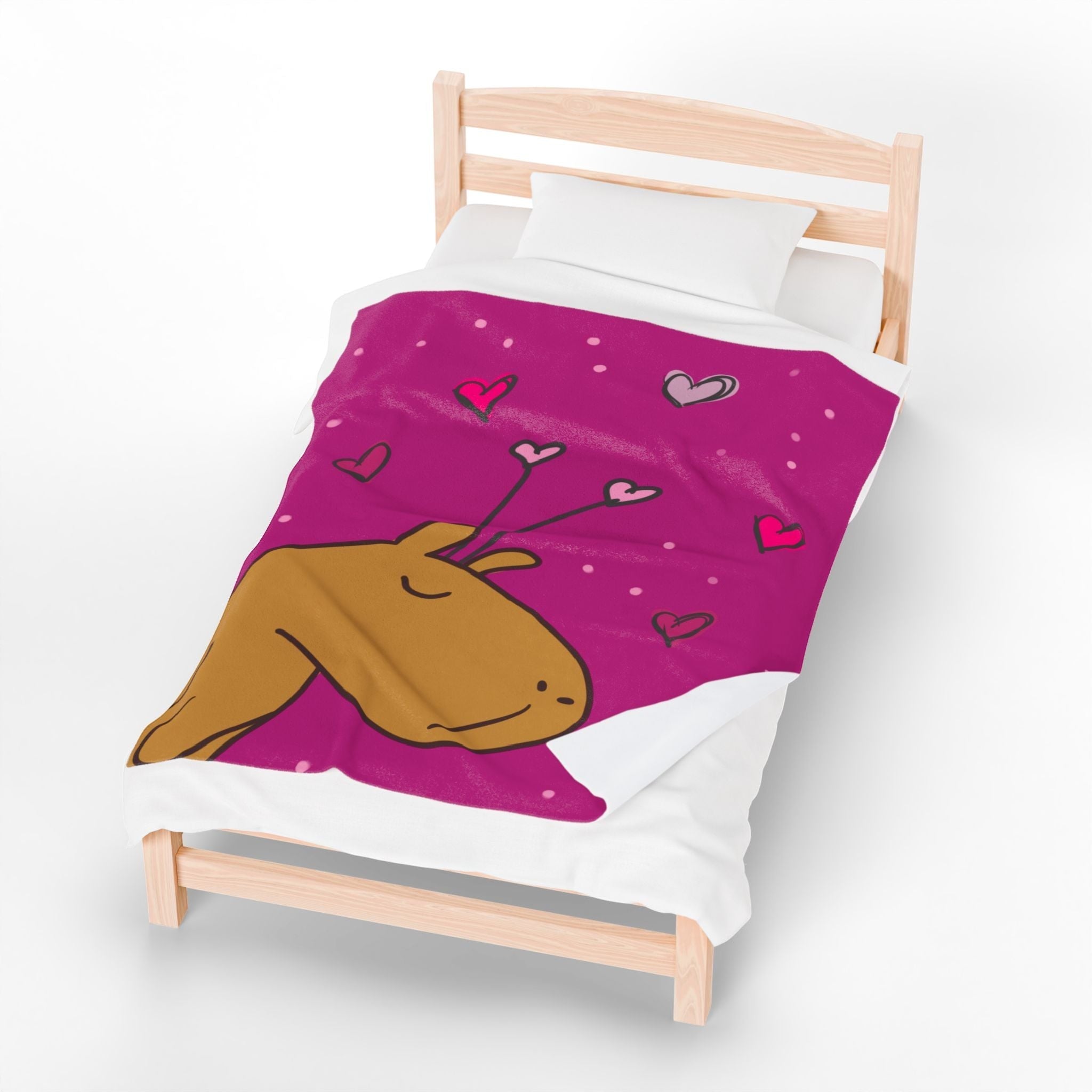 Capy Life personalized pink velveteen throw blanket featuring a cute capybara illustration and heart doodles on a bed.