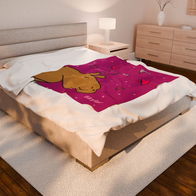 Capy Life personalized pink velveteen throw blanket featuring a capybara illustration and hearts on a bedroom bed.