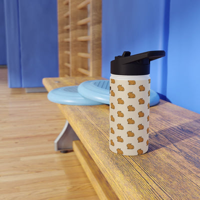 Capy Life personalized kids water bottle with a cute capybara pattern on a wooden bench in a gym setting.