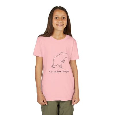 A smiling girl wearing a light pink Capy Life kids graphic tee featuring a cute capybara on roller skates.