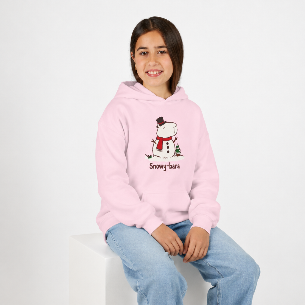 Capy Life youth hoodie in light pink featuring a Snowy-bara capybara snowman graphic worn by a smiling girl.