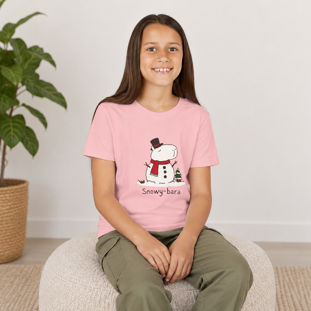 Capy Life youth t-shirt in light pink featuring a cute Snowy-bara snowman capybara graphic worn by a smiling girl.