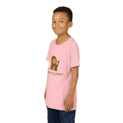 Young boy wearing a light pink Capy Life kids t-shirt featuring a cute wizard capybara graphic and text.