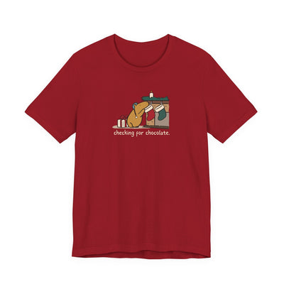 Capy Life red softstyle t-shirt featuring a hand-drawn capybara checking a Christmas stocking for chocolate.