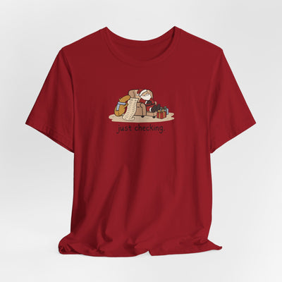 Capy Life red short-sleeve t-shirt featuring a hand-drawn illustration of a capybara checking Santa's naughty list.