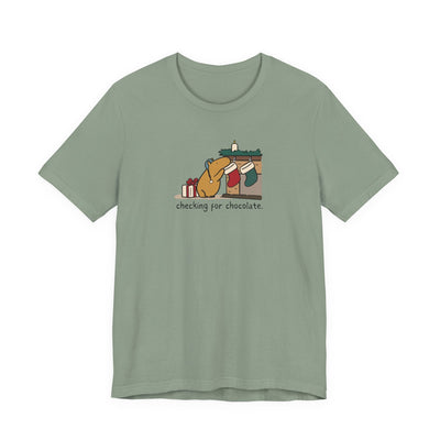 Capy Life sage green crewneck t-shirt with a hand-drawn capybara checking a Christmas stocking for chocolate.