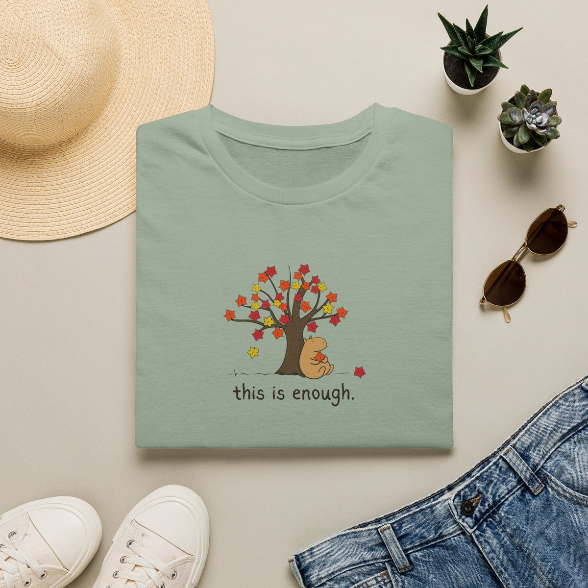 Capy Life sage green softstyle t-shirt featuring a hand-drawn capybara under an autumn tree with the text this is enough
