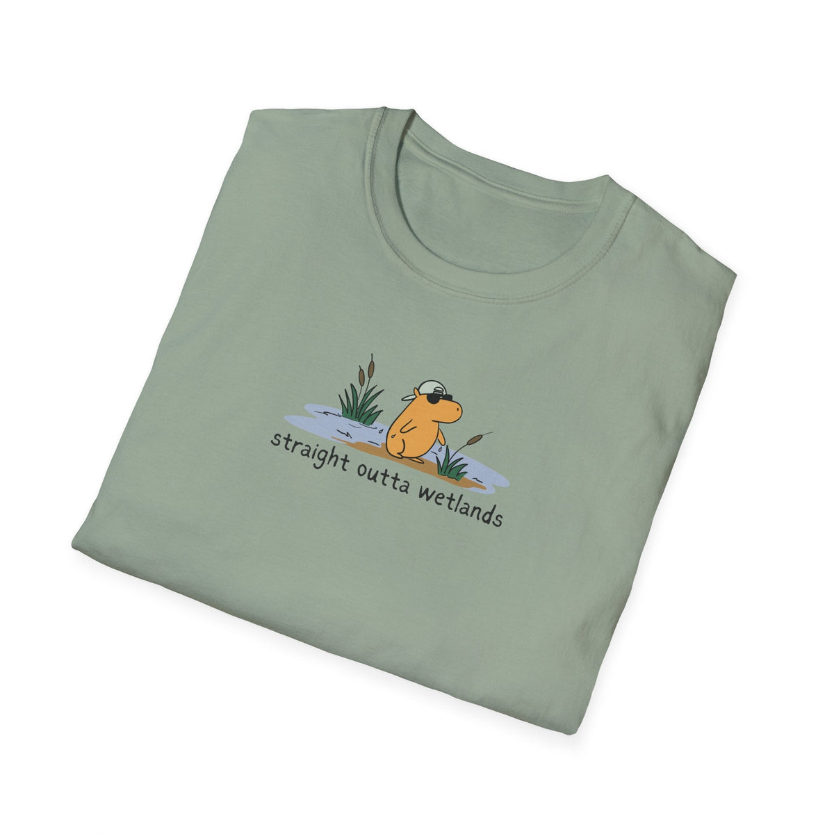 Capy Life sage green softstyle t-shirt featuring a hand-drawn capybara wearing a backwards hat in a wetland scene.