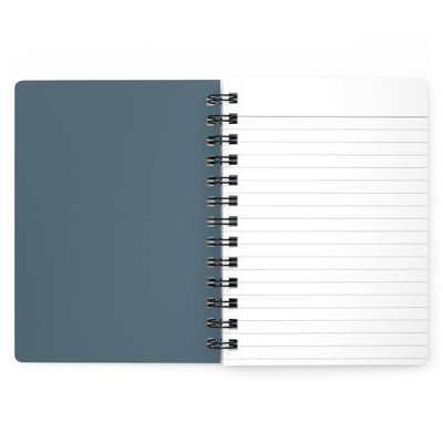 Capy Life spiral notebook with a muted blue cover and lined white paper pages open on a flat surface.