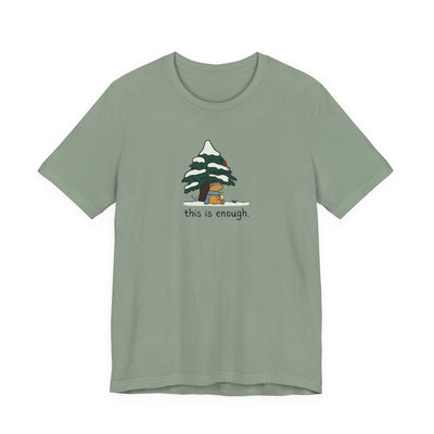 Capy Life sage green t-shirt featuring a cute capybara in a blue scarf under a snowy evergreen tree with text.