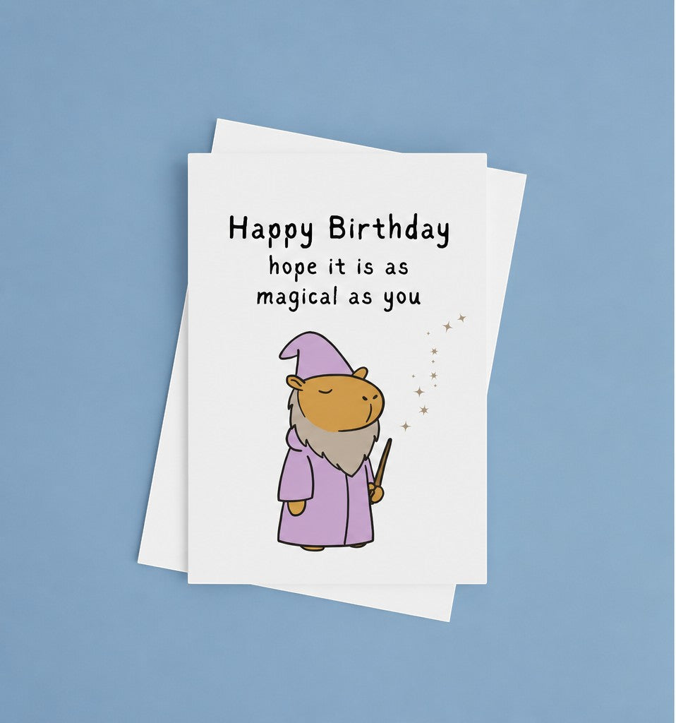 Capy Life birthday card featuring a cute capybara in a purple wizard robe and hat casting a spell with a wand