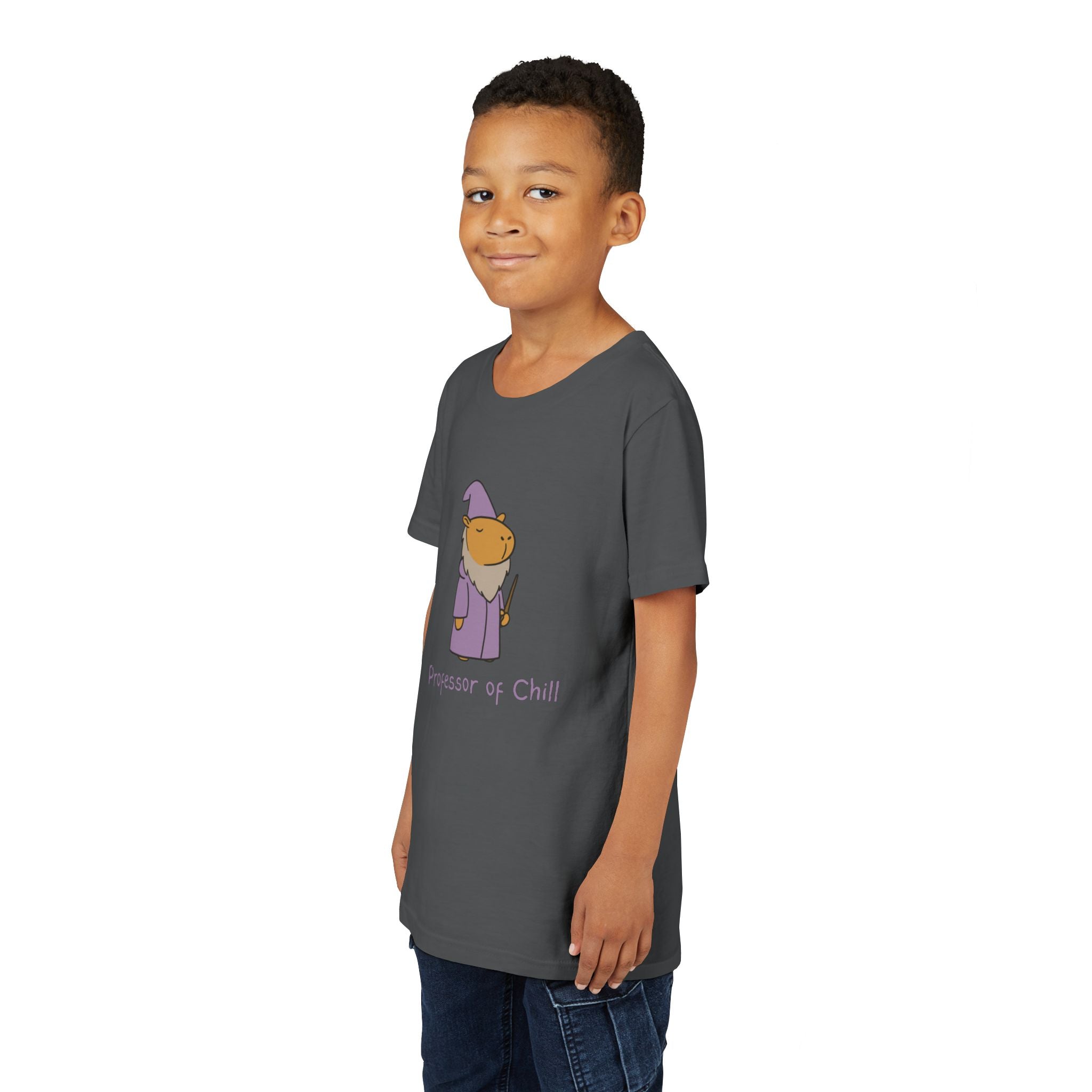 A young boy wearing a dark grey Capy Life cotton t-shirt featuring a wizard capybara graphic and Professor of Chill text