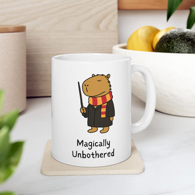 Capy Life white ceramic mug featuring a wizard capybara in a striped scarf holding a wand with Magically Unbothered text